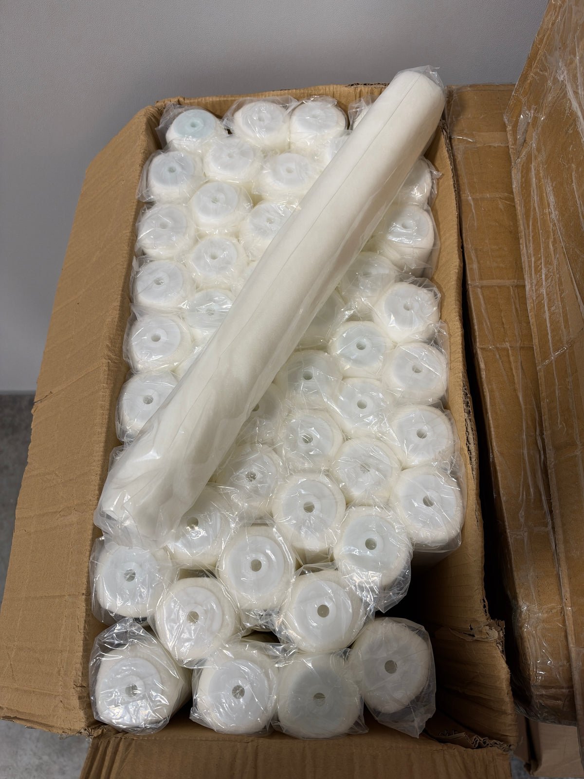 Open box of 18-inch roller covers with one cover pulled out